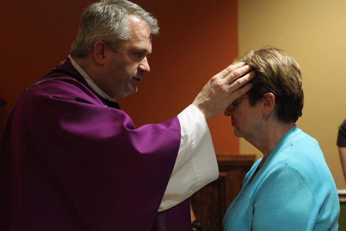 CHARLOTTE —Father Patrick Winslow, vicar general and chancellor, distributes ashes at the Pastoral Center in Charlotte on Ash Wednesday. (Photos by SueAnn Howell) 