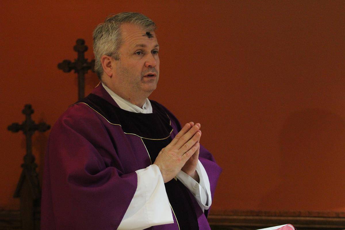 CHARLOTTE —Father Patrick Winslow, vicar general and chancellor, distributes ashes at the Pastoral Center in Charlotte on Ash Wednesday. (Photos by SueAnn Howell) 